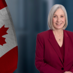 Minister Hajdu in front of Canadian Flags